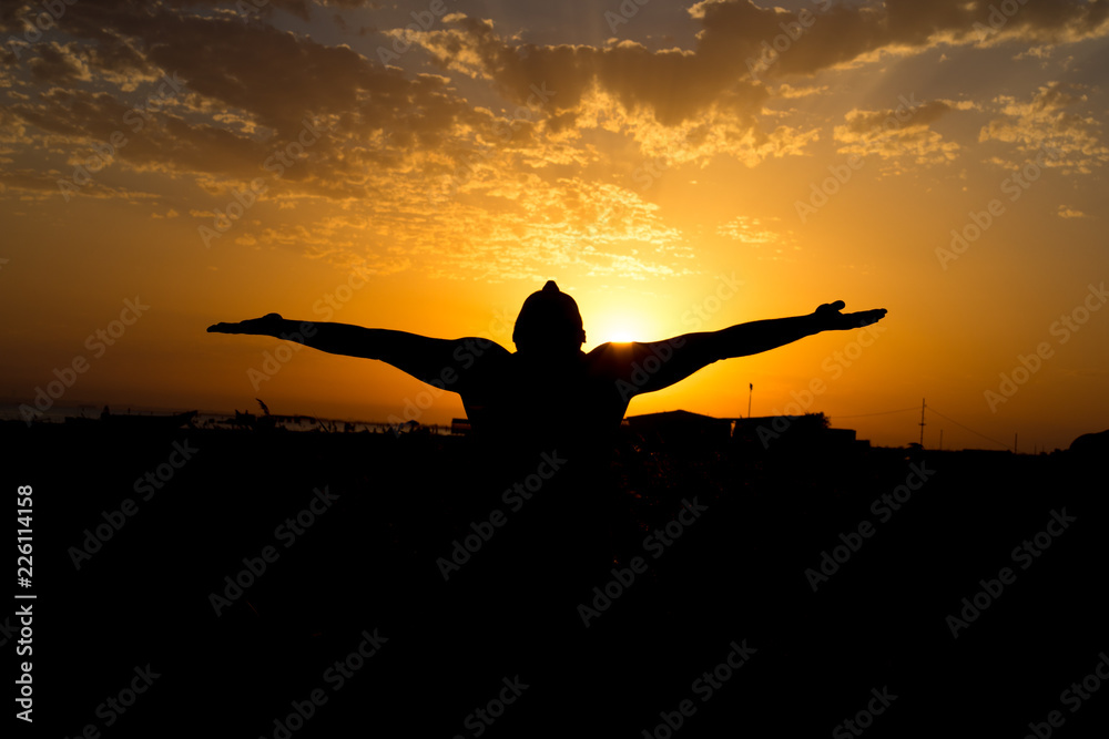 Silhouette of man with their hands in the sunset. Outdoor shot