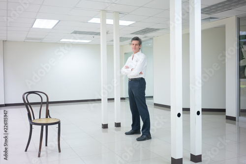 Wallpaper Mural Businessman standing in empty bright office and looking  smiling at camera. Torontodigital.ca