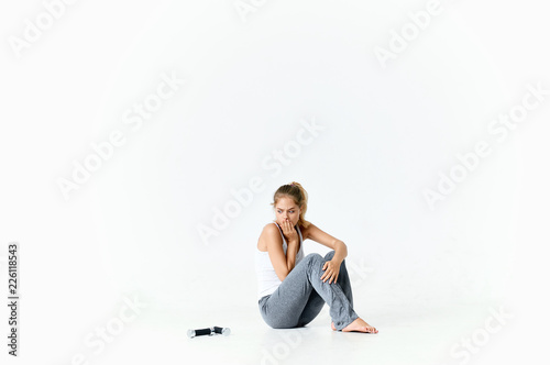 young woman sitting on the floor over isolated background