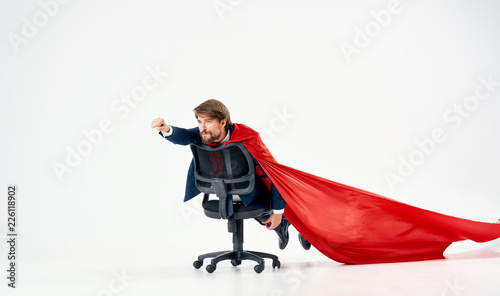 man riding on a chair in a red raincoat hero superman