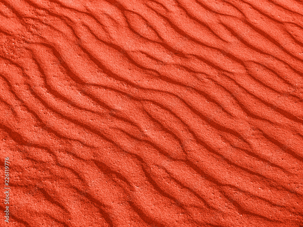 texture of red sand waves on the beach or in the desert. the ripples of the sand is diagonal. texture of red sand waves on the beach or in the desert. the ripples of the sand is diagonal.