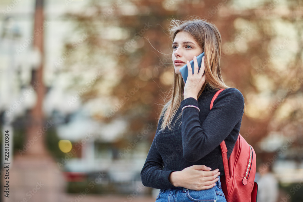 Young Russian girl talking on the phone.  Girl calling on the phone. center of Moscow