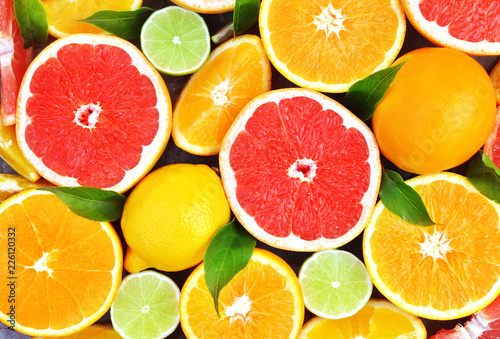 Fotografia Fresh ripe sweet citrus fruits colorful background: orange, grapefruit, lime, le