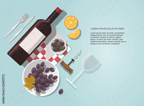 Wine glass, wine bottle, olives and grapes composition on blue background. 