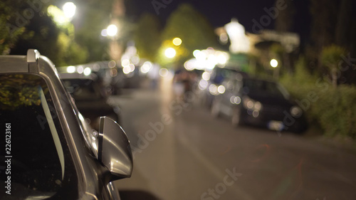 Blurred background plate of parked cars parked on street at night