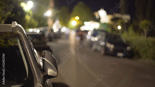 Obraz na plátně Blurred background plate of parked cars parked on street at night