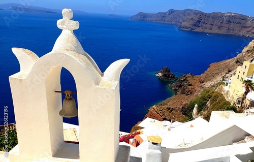 Traditional church in Santorini, overlooking the stunning Aegean coastline and mountainous regions in the distance.
