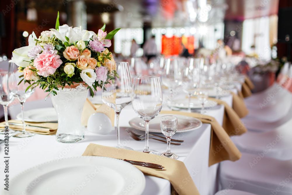 Table at a luxury wedding reception. Beautiful flowers on the table. Serving dishes, glass glasses, waiters work, Table at a luxury wedding reception. Beautiful flowers on the table. Serving dishes, glass glasses, waiters work,