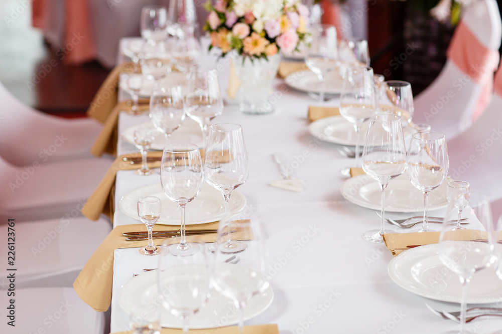 Table at a luxury wedding reception. Beautiful flowers on the table. Serving dishes, glass glasses, waiters work, Table at a luxury wedding reception. Beautiful flowers on the table. Serving dishes, glass glasses, waiters work,