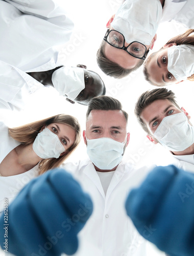 Team of medical doctors looking down at patient