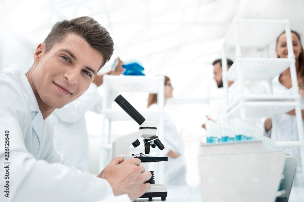 cheerful laboratory worker using microscope in lab cheerful laboratory worker using microscope in lab