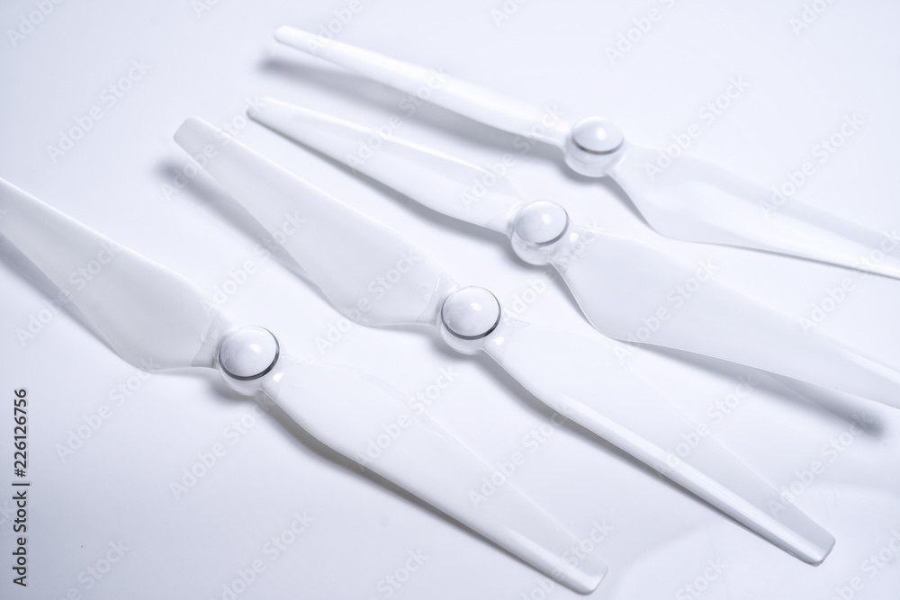 A white drone propeller arm with a rigid type of propeller forward on white isolated background