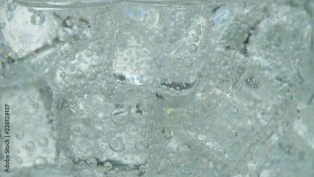 Pouring soda water with ice and bubbles in the glass Pouring soda water with ice and bubbles in the glass