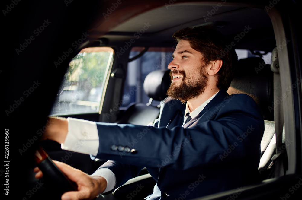 smiling business man driving a luxury car