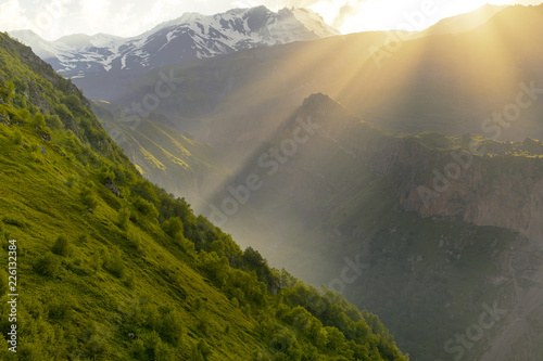 Sun rays between mountain peaks in Georgia 