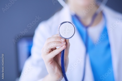 Close-up shot of doctor's hands holding stethoscope at clinic.