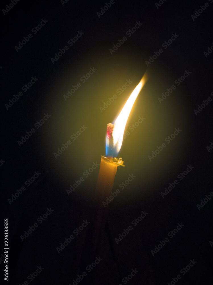 Fototapeta premium Candle flame close up on a black background