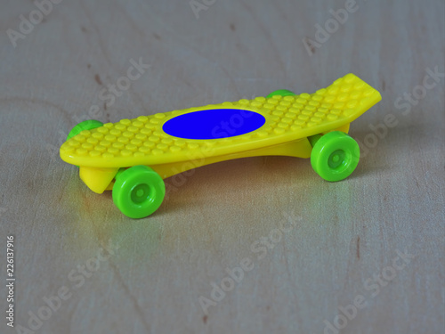 Yellow skateboard with green whells photo