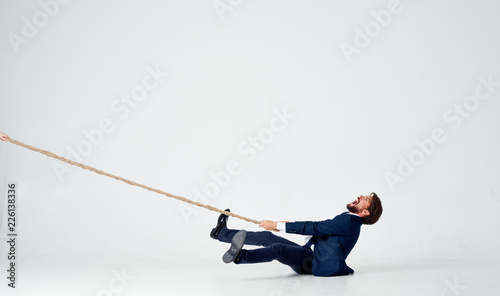 business man pulls the rope on an isolated white background photo