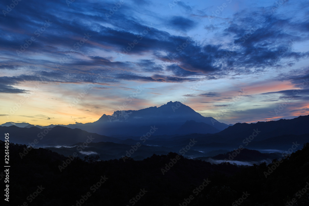 Beautiful sunrise landscape scenery with sunlight and fog and Mount Kinabalu as background in Guakon, Sabah, Malaysia