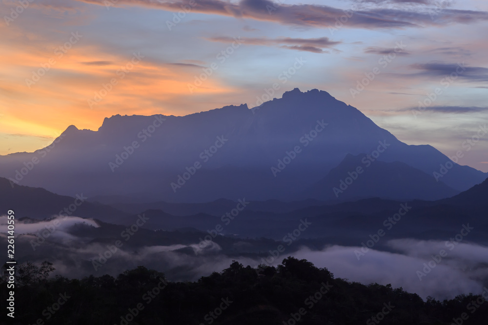 Beautiful sunrise landscape scenery with sunlight and fog and Mount Kinabalu as background in Guakon, Sabah, Malaysia