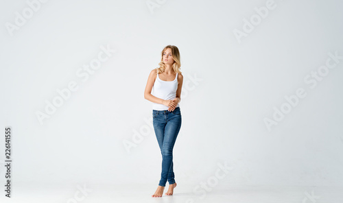 woman in white t-shirt in jeans in full growth on an isolated background