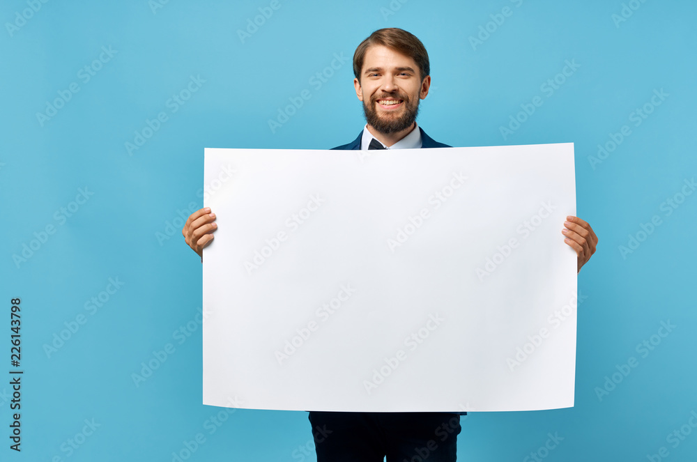 Joyful business man with a white sheet on a blue background, a free place Joyful business man with a white sheet on a blue background, a free place