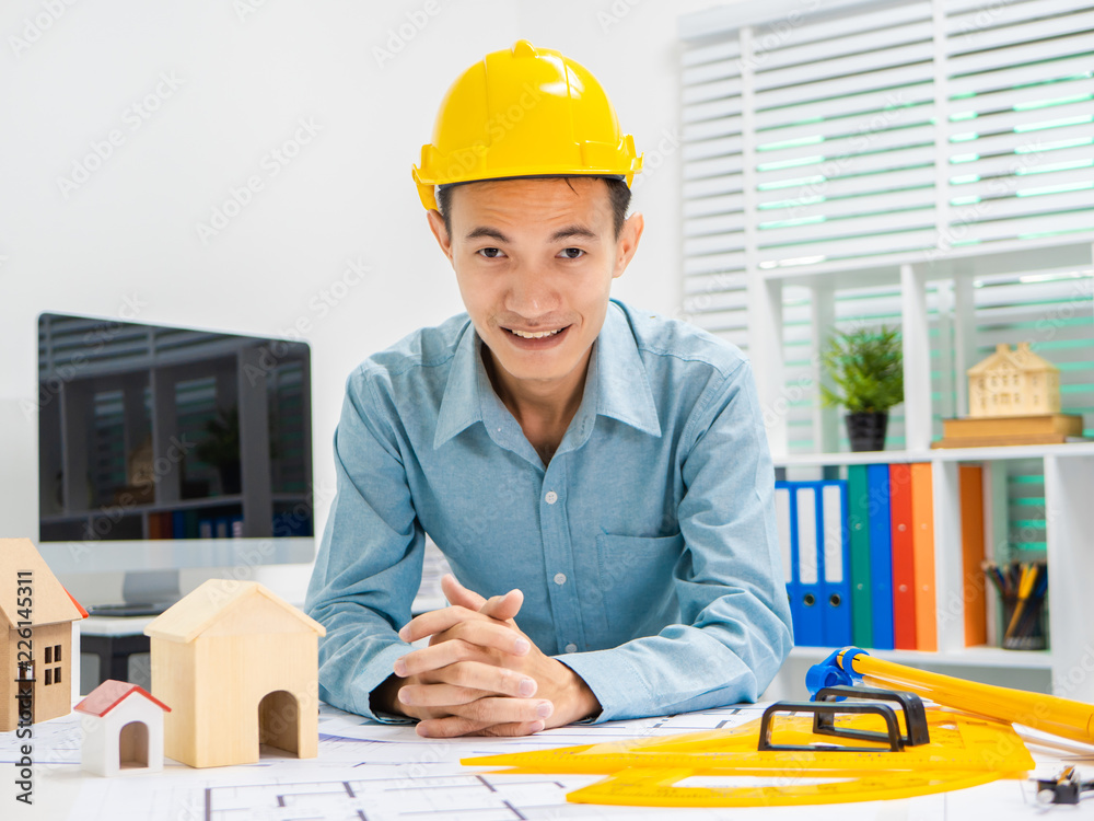 Young Asian man architect working at working desk about his housing project. Young Asian man architect working at working desk about his housing project.