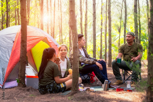 Asian people hiking with tent in the forest and camping during summer at sunset. © Natnan