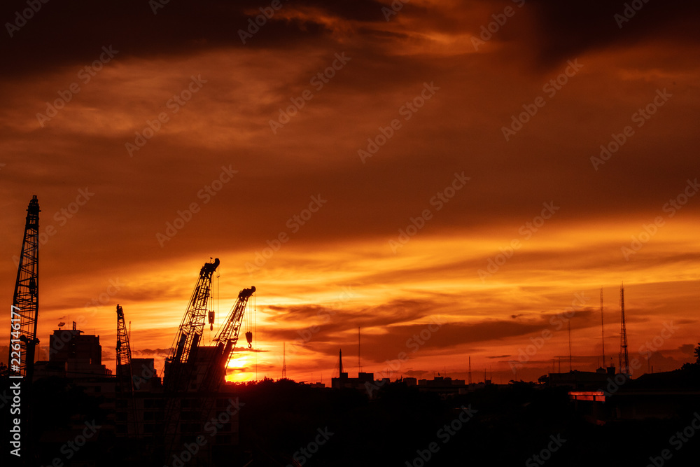 Silhouette of construction site with sunset sky
