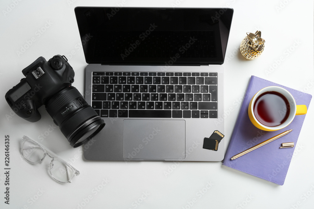 Photographer's workplace with laptop and camera on table, top view Photographer's workplace with laptop and camera on table, top view