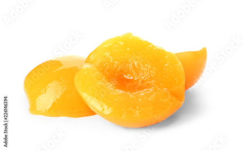 Halves of canned peaches on white background