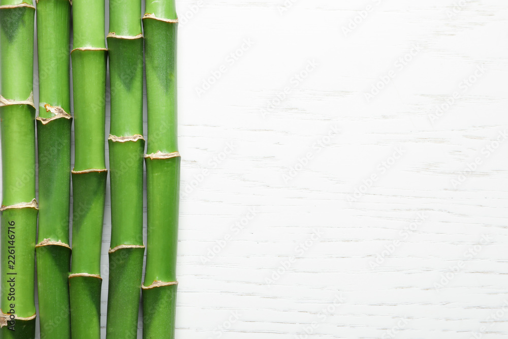 Green bamboo stems and space for text on wooden background, top view Green bamboo stems and space for text on wooden background, top view