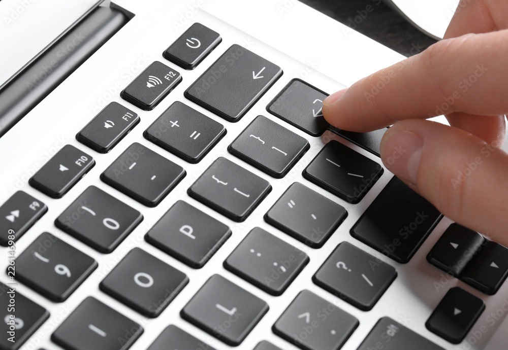 Woman pressing button on laptop keyboard, closeup Woman pressing button on laptop keyboard, closeup
