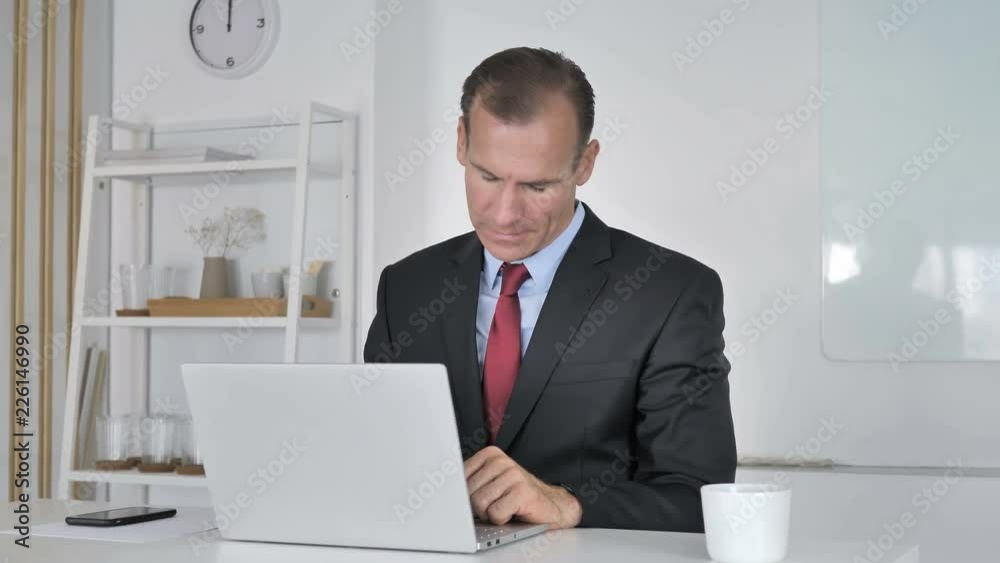 Middle Aged Businessman with Neck Pain working on Laptop Middle Aged Businessman with Neck Pain working on Laptop