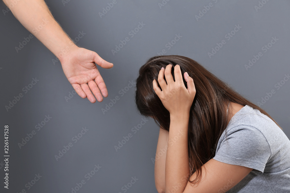 Man giving helping hand to depressed woman on gray background Stock Photo |  Adobe Stock