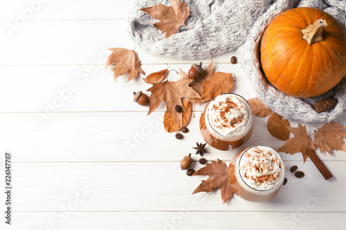 Flat lay composition with glasses of tasty pumpkin spice latte and space for text on wooden background