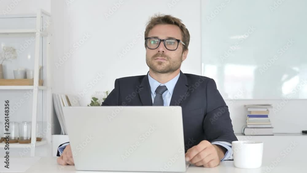 Thinking and Smiling Businessman Sitting in Office Thinking and Smiling Businessman Sitting in Office