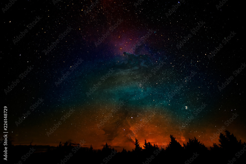 Milky way and fantasy galaxy clouds above the forest landscape, collage. The elements of this image furnished by NASA.