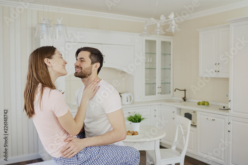 Young couple having fun in the kitchen. Romance in the relationship of man and woman.
