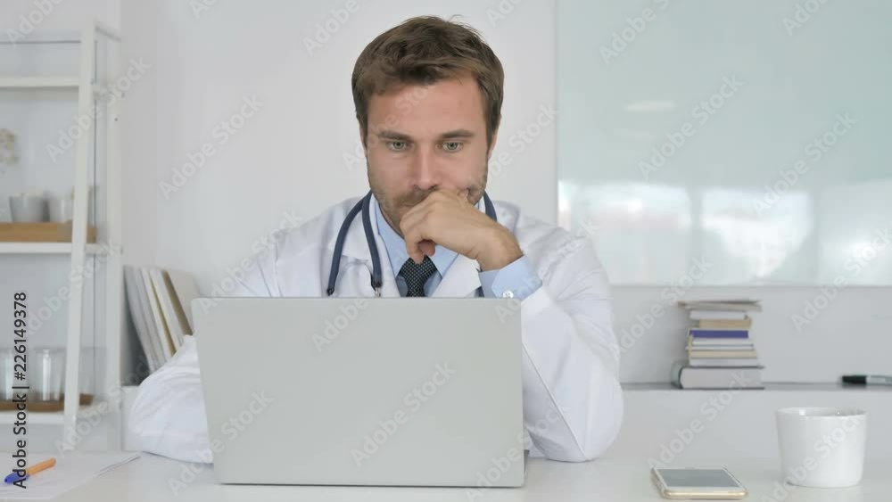 Pensive Doctor Thinking and Working on Laptop Pensive Doctor Thinking and Working on Laptop