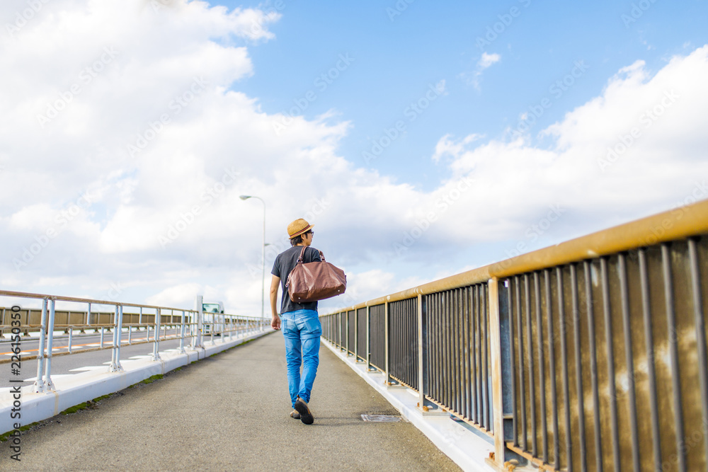 橋の上を歩く男性