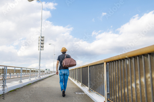 橋の上を歩く男性