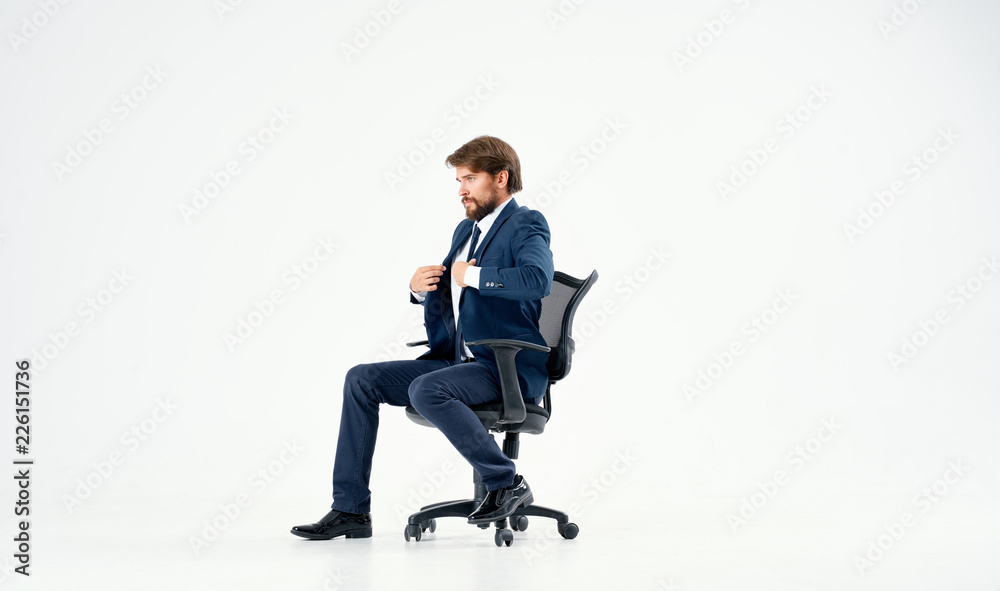 business man sitting on a chair straightening his jacket business man sitting on a chair straightening his jacket