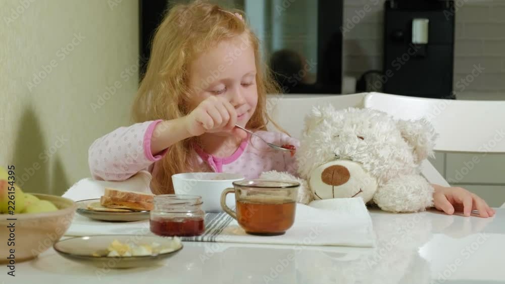 little girl eating porridge in the kitchen at home little girl eating porridge in the kitchen at home