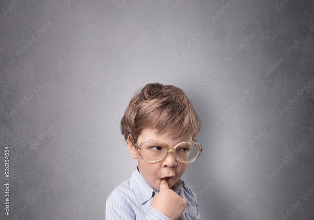 Adorable little boy portrait with empty grey wall background Adorable little boy portrait with empty grey wall background
