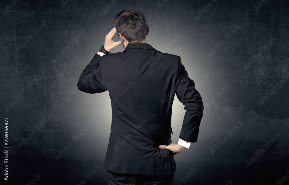 Young businessman standing and thinking alone