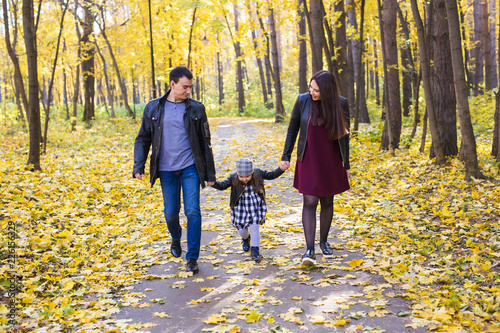 Fall, nature and family concept - happy family walking in autumn park © satura_