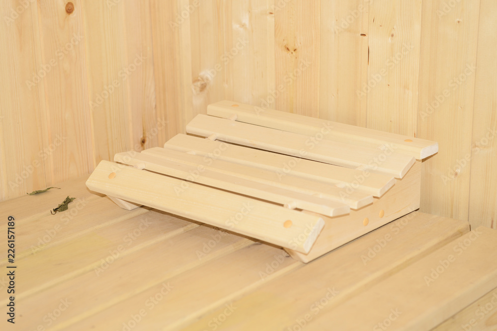 wooden headrest made of linden on the shelf in the sauna wooden headrest made of linden on the shelf in the sauna
