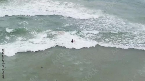 surfer going into waves photo